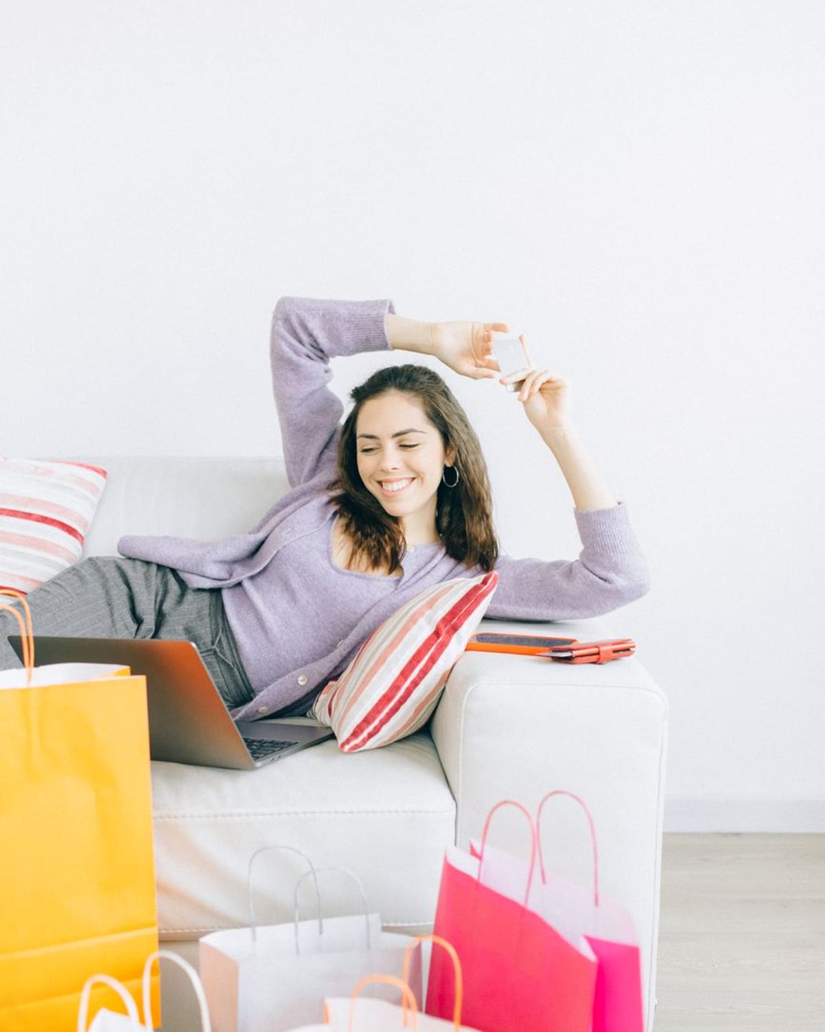 Choosing a product at home with a laptop and shopping bags
